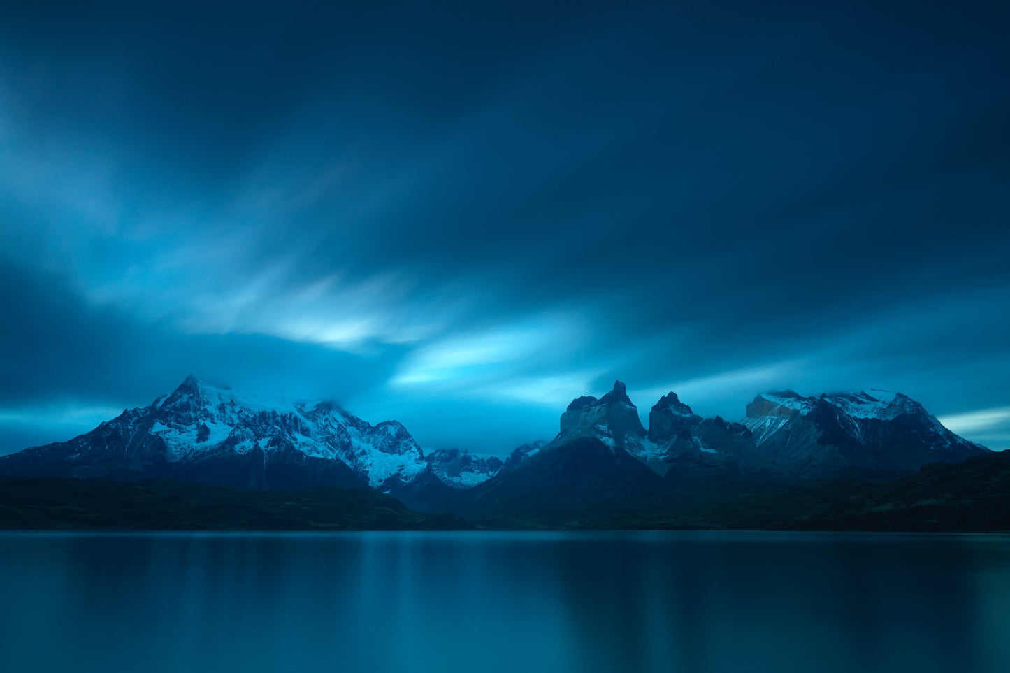 clouds streak passed over the lake and Torres del Paine mountains in Chile